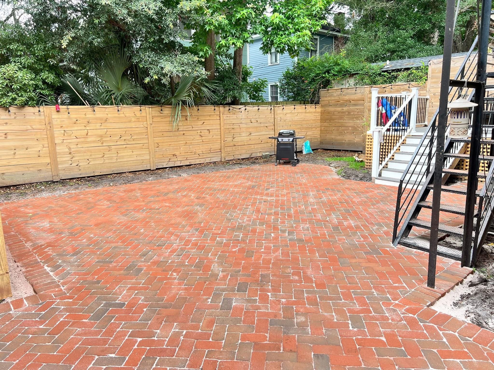 Reclaimed brick courtyard running up to an exterior staircase
