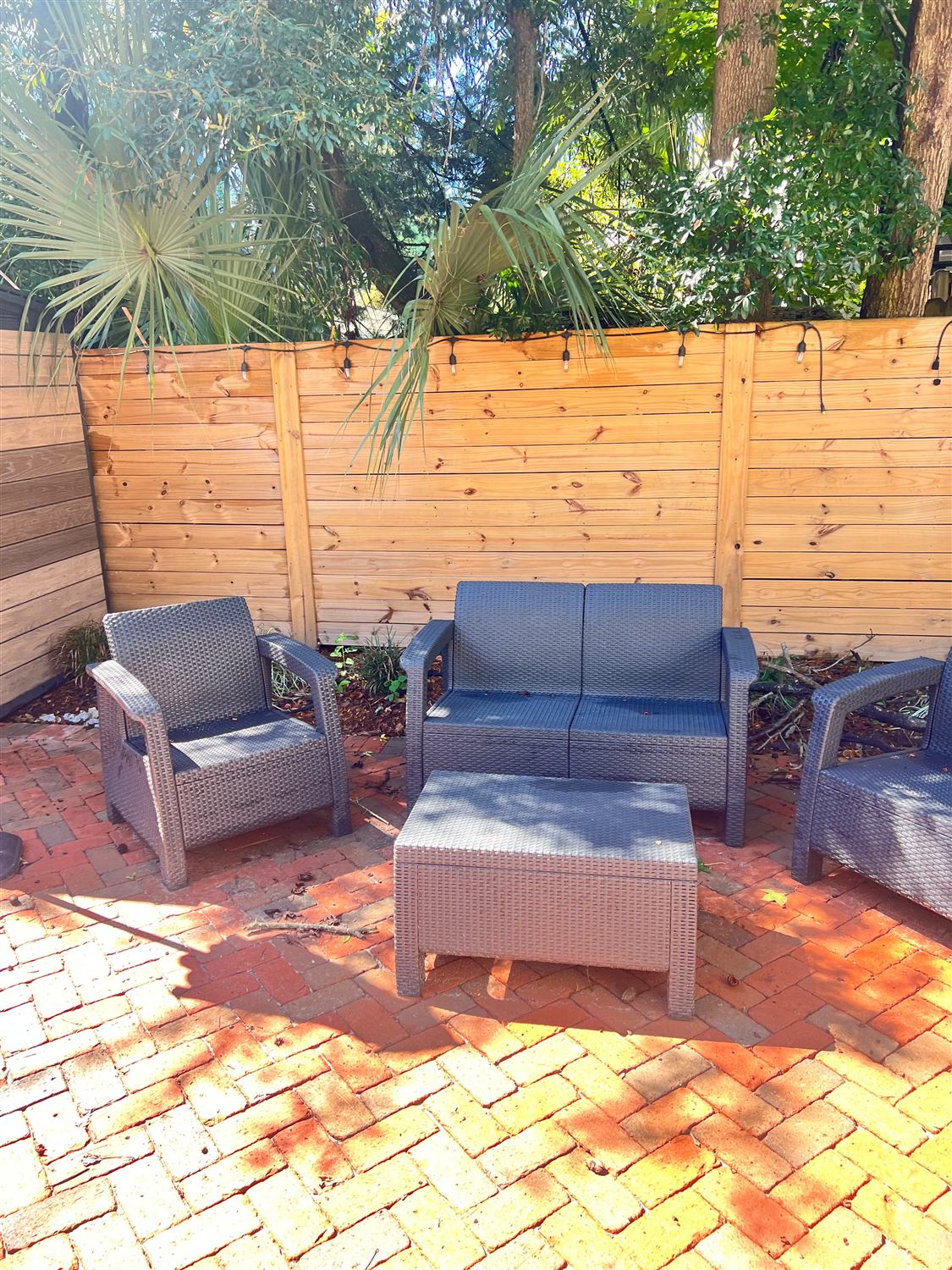 Brick patio with outdoor seating against a horizontal wood fence