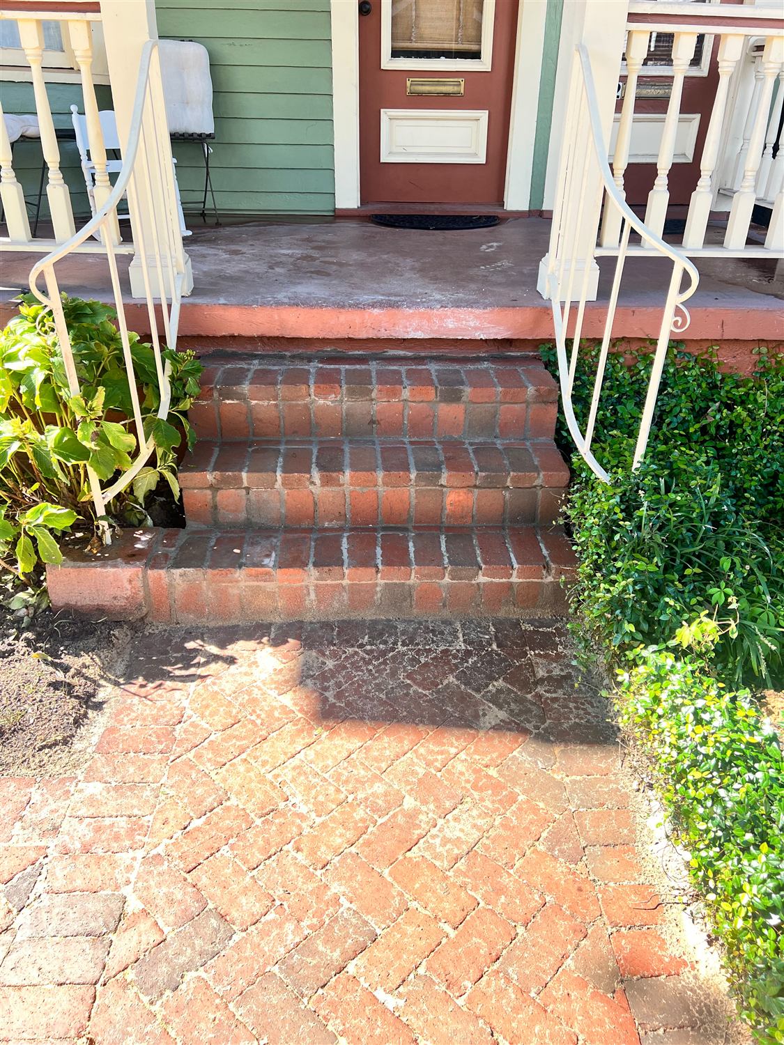 Brick front steps and herringbone walk leading to a historic porch