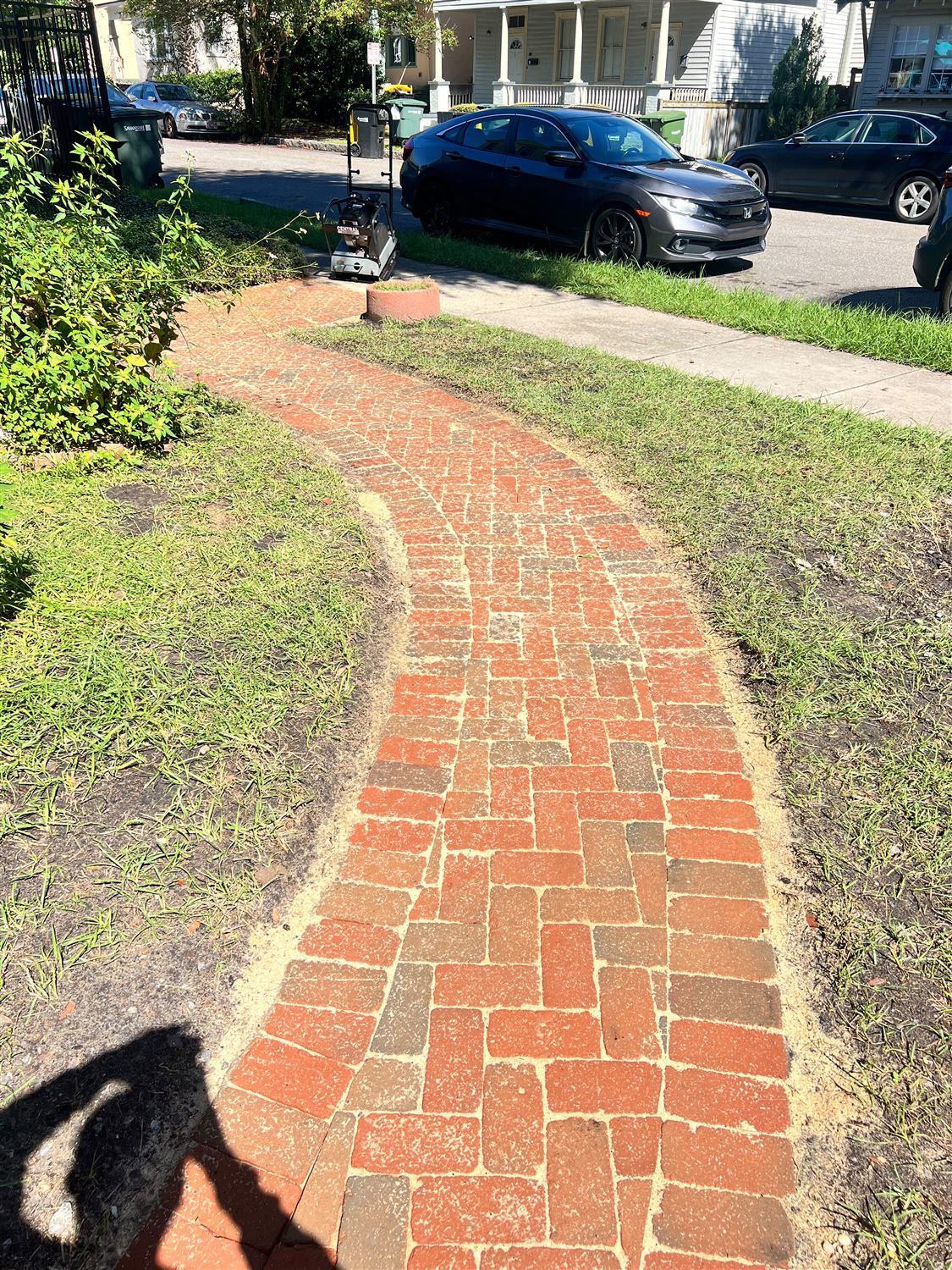 Curved reclaimed brick walkway from the sidewalk to the front of a home