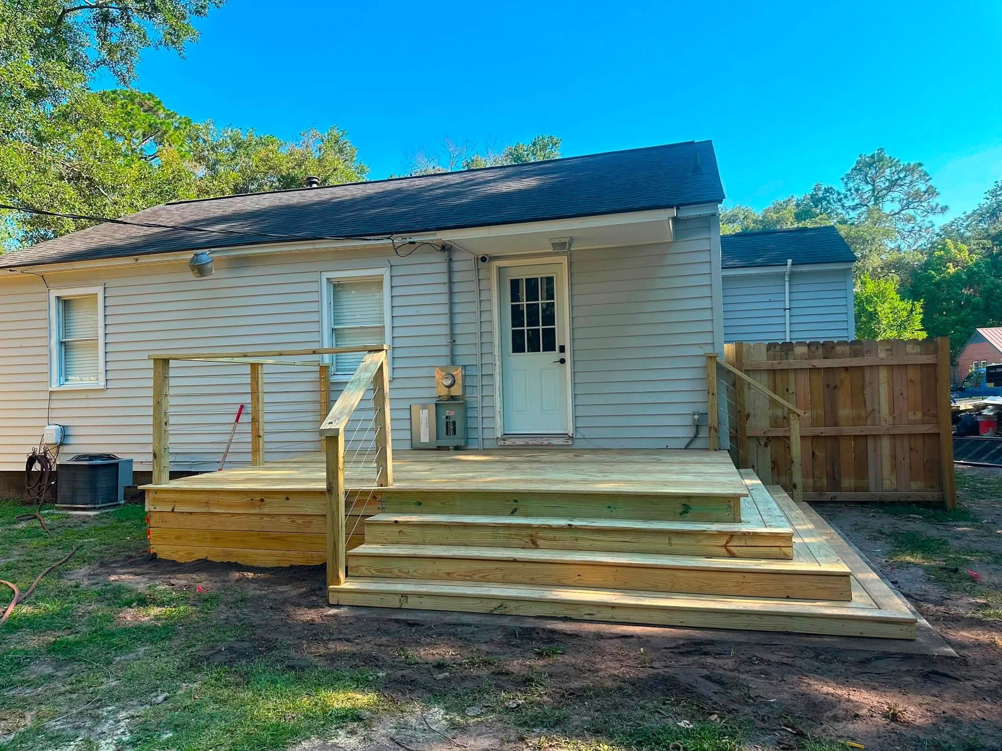 Rear deck with cable railing beside a back door