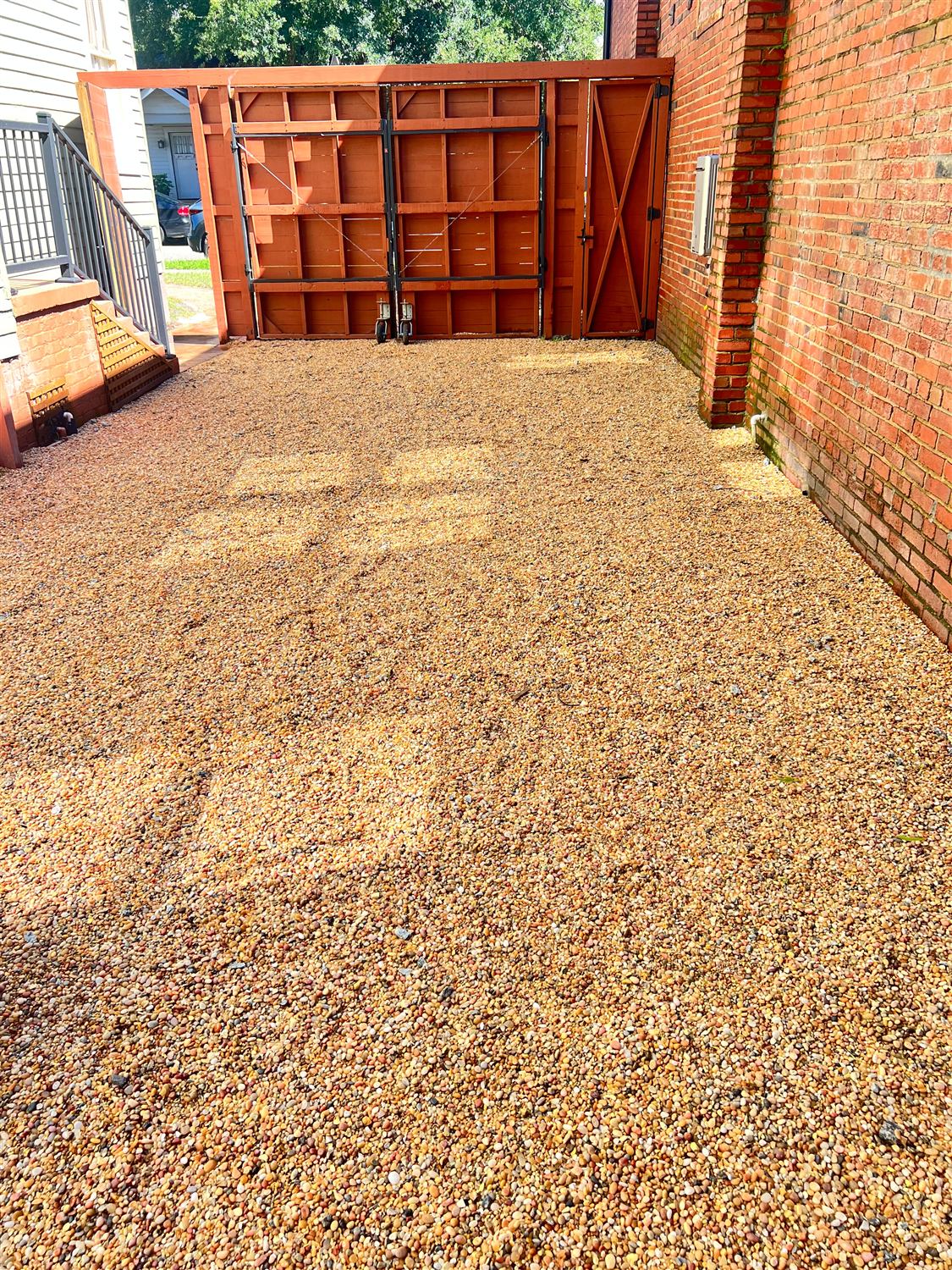 The same side yard finished with pea gravel up to the wood gates