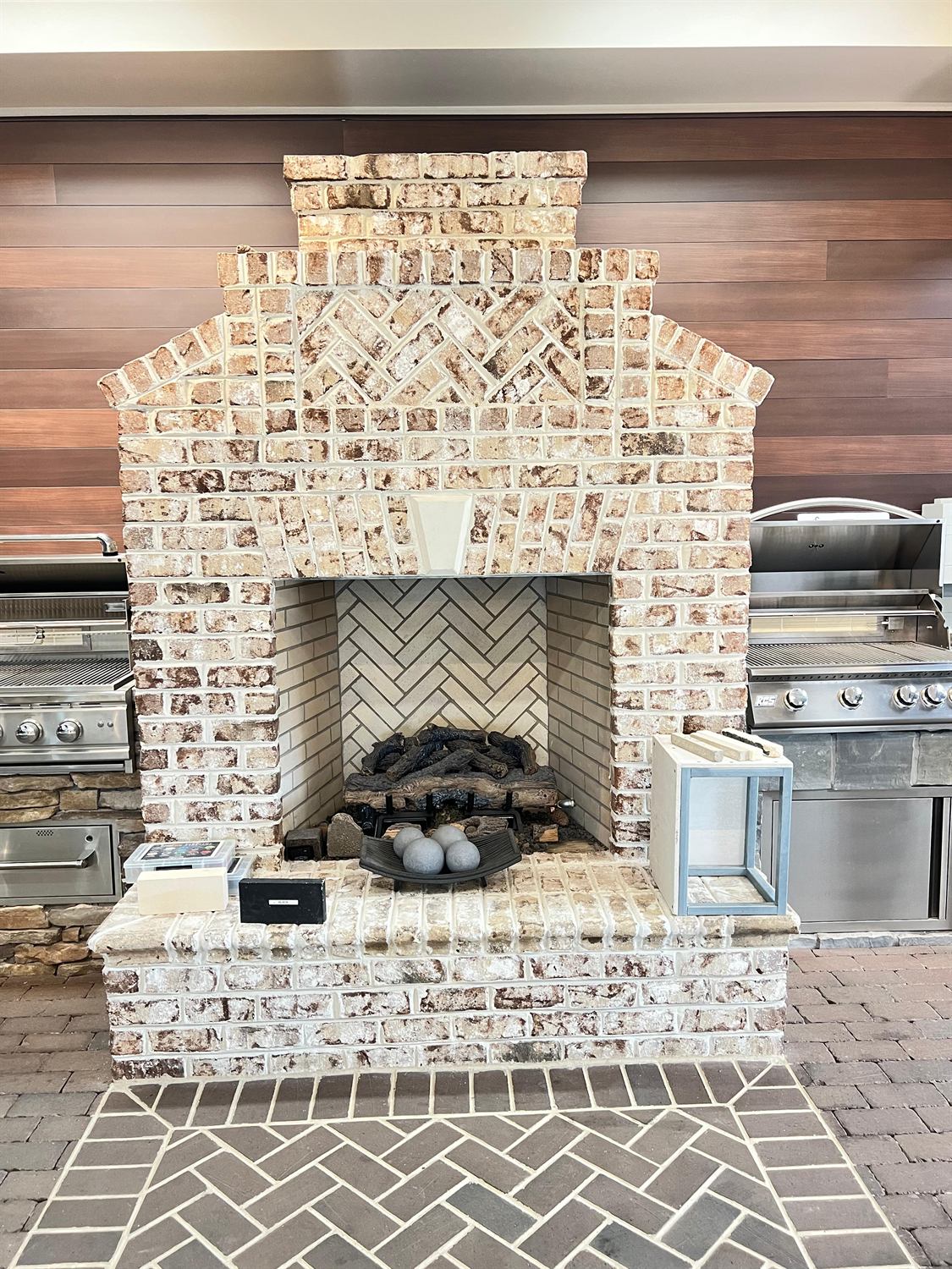 Brick outdoor fireplace with a herringbone firebox, built by Lalo's Home Improvements