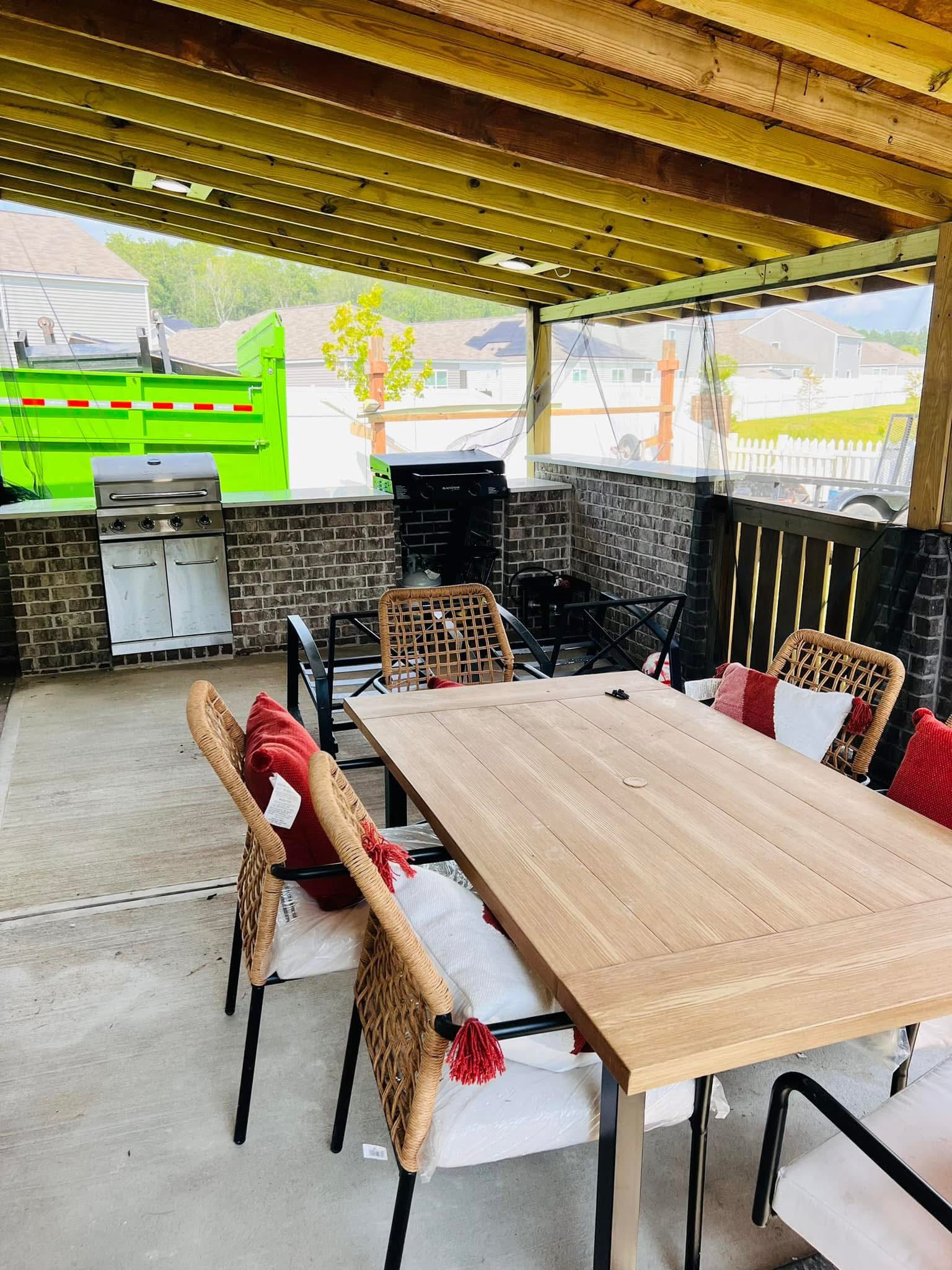 Covered outdoor kitchen and dining area with brick counters and clear side curtains