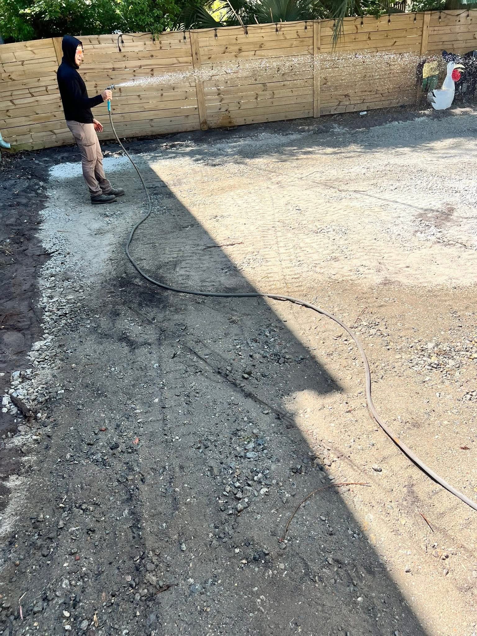 Crushed stone base being graded and wetted before pavers are laid