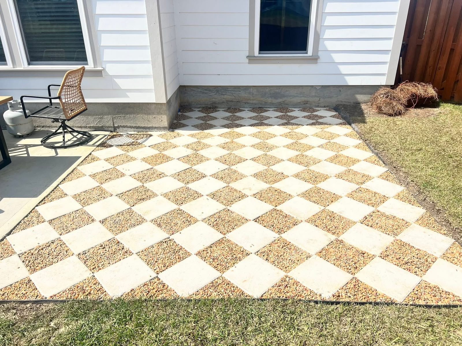 Checkerboard patio of square slabs set in pea gravel