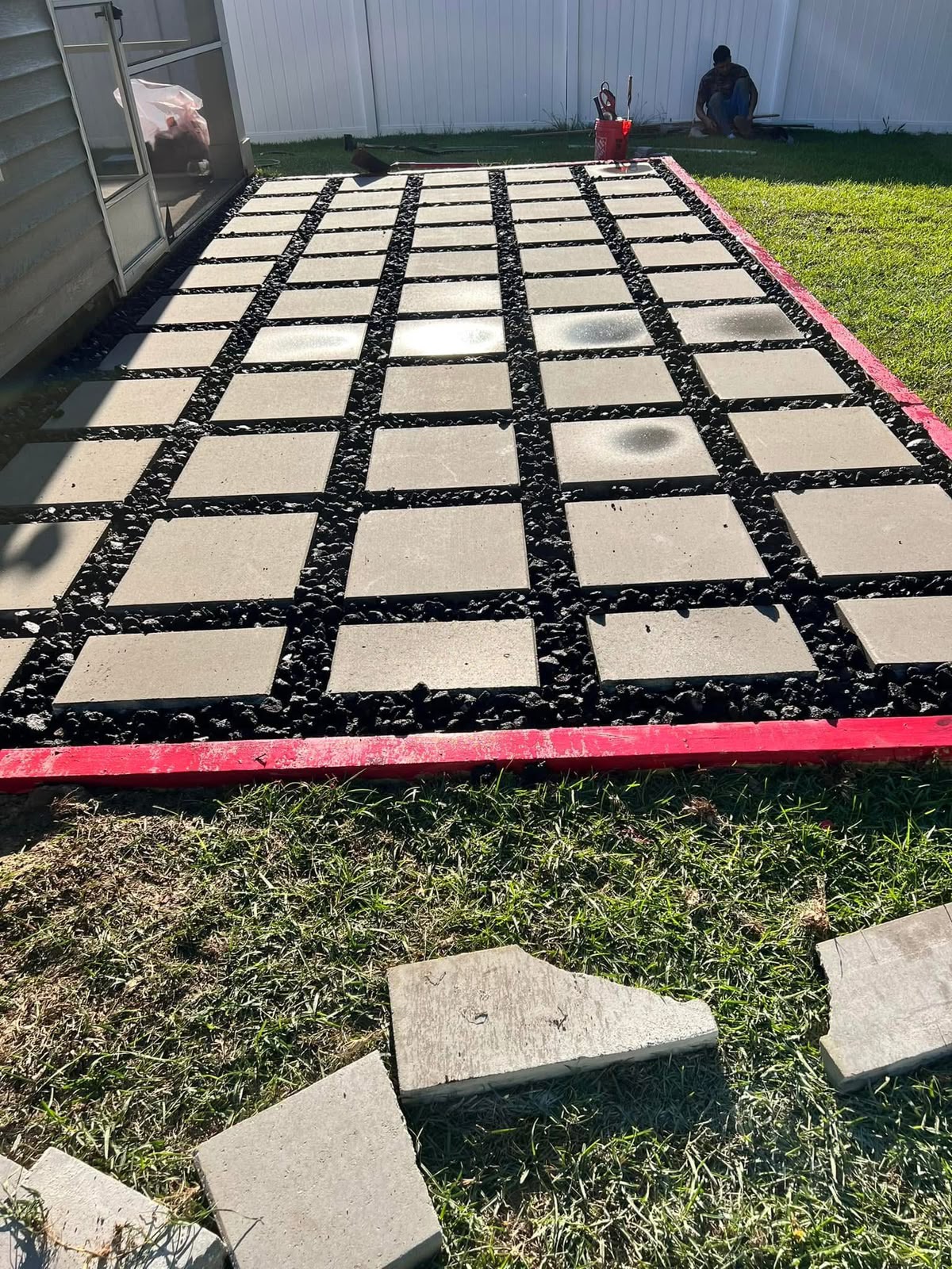 Square pavers set in a grid with black lava rock between them