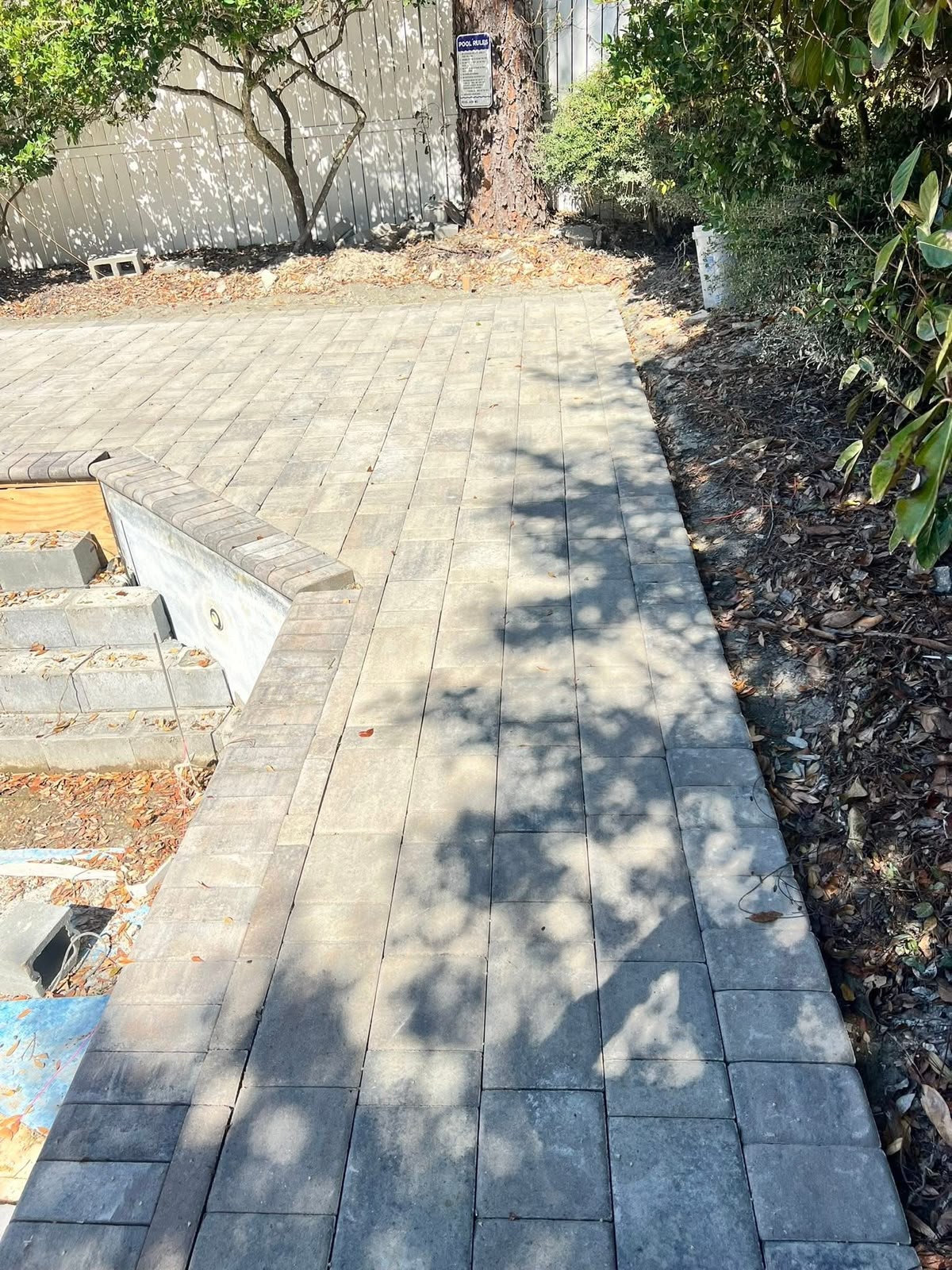 Paver pool deck with a charcoal border course and coping