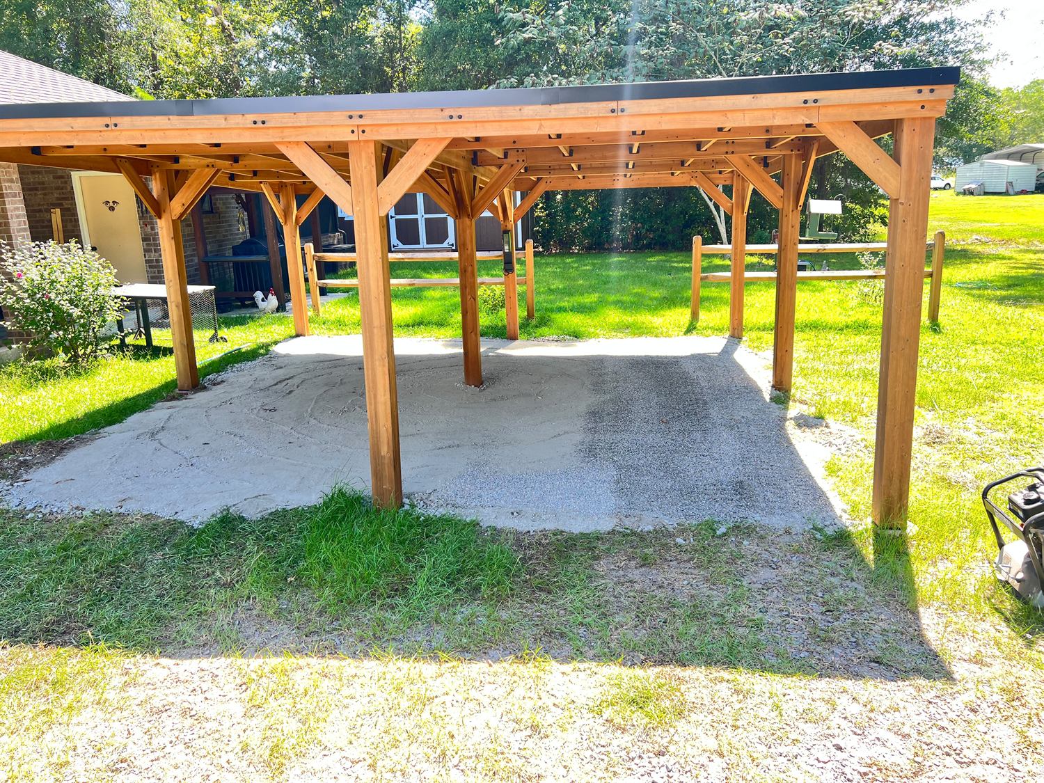 Cedar pavilion seen from the side showing the braced post-and-beam framing