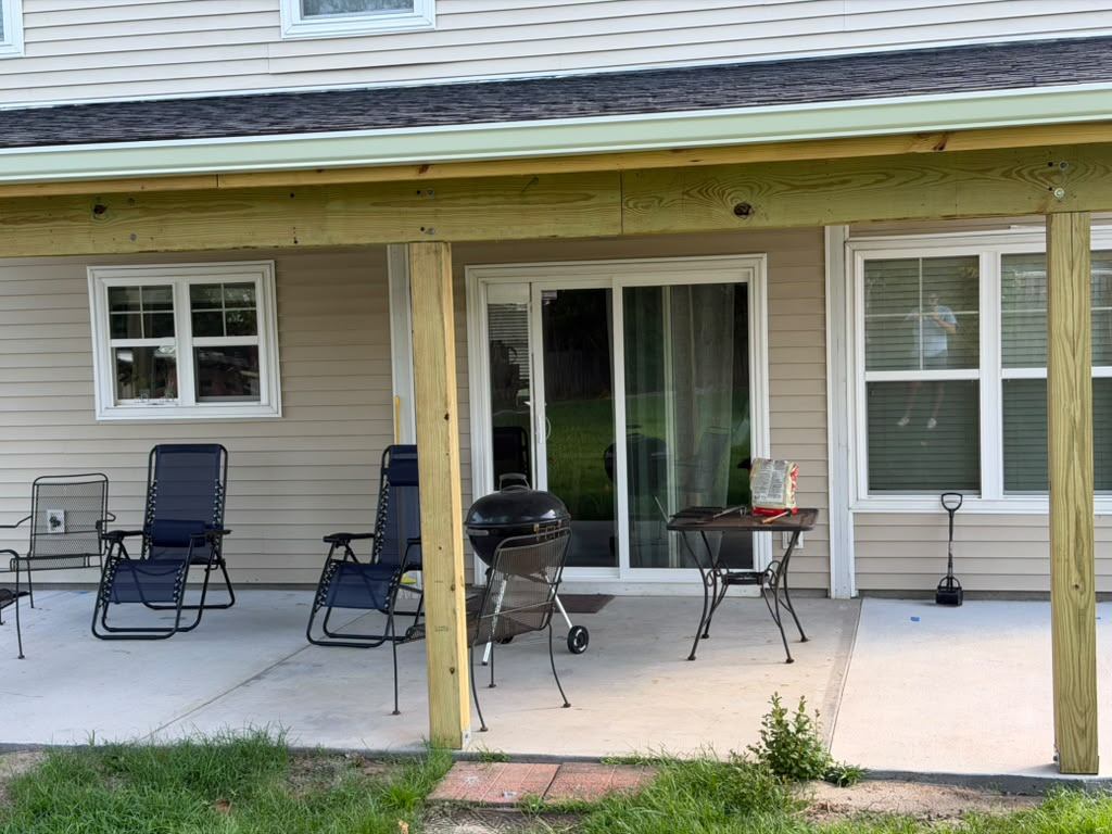 The finished porch in use with chairs, table and a grill