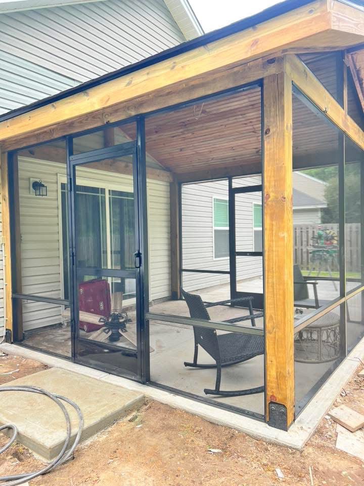 Cedar and black screened porch attached to the back of a home