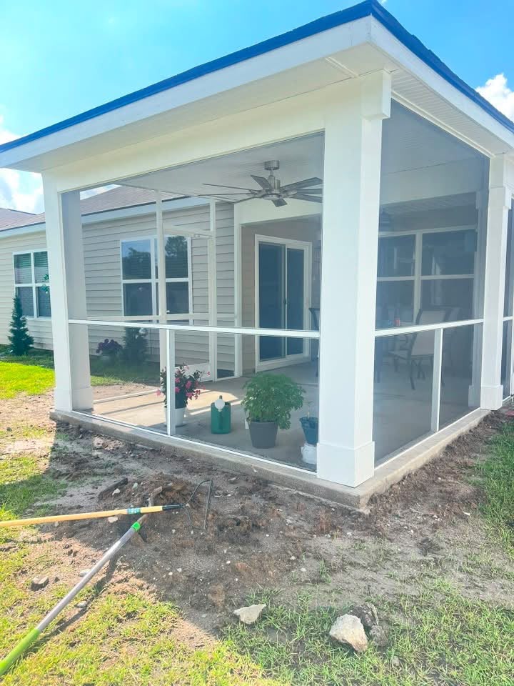 White screened porch with a ceiling fan attached to a home