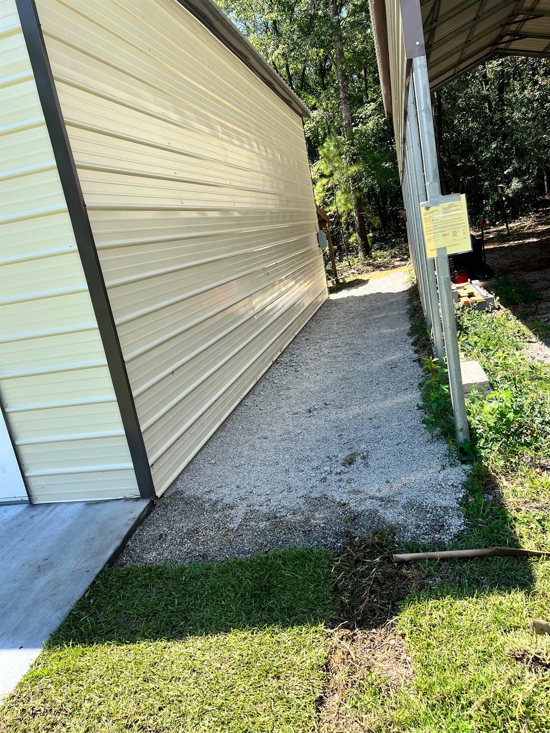 Compacted gravel path running along the side of a metal building