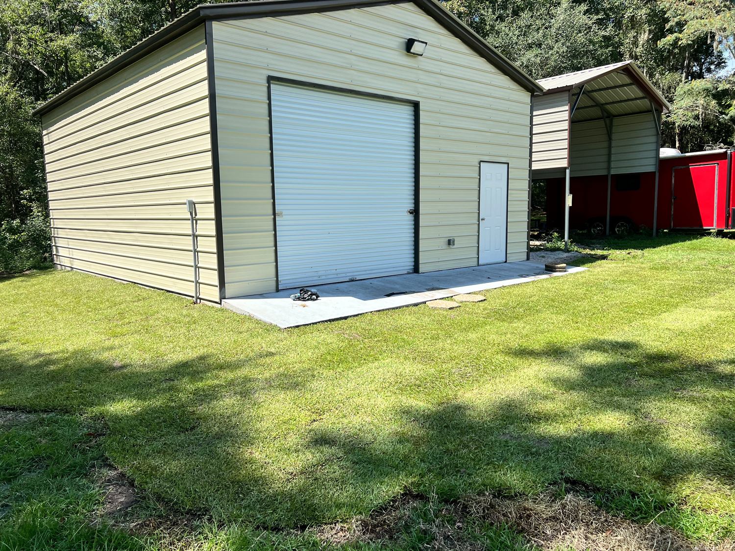 Metal garage surrounded by newly laid sod, fully finished
